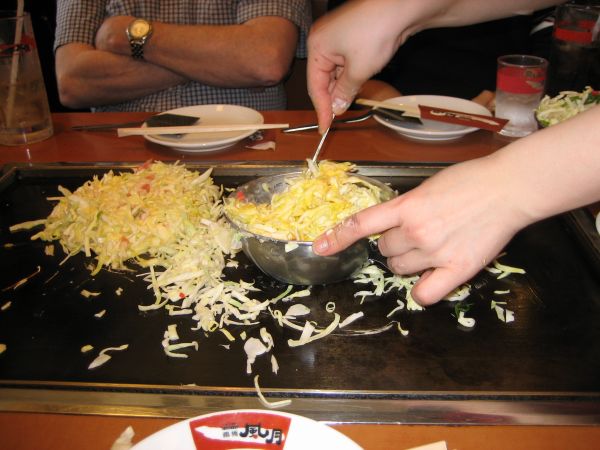 Okonomiyaki being mixed at my table